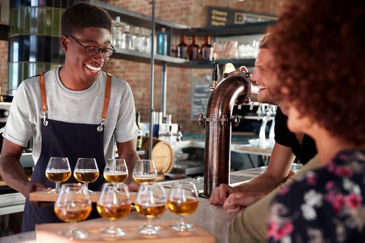 Man serving flight of beers