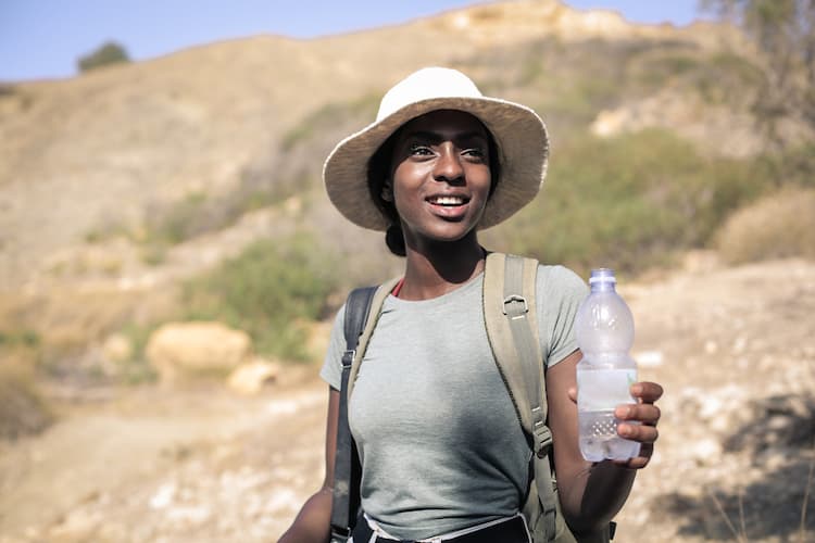 Woman in desert with water bottle