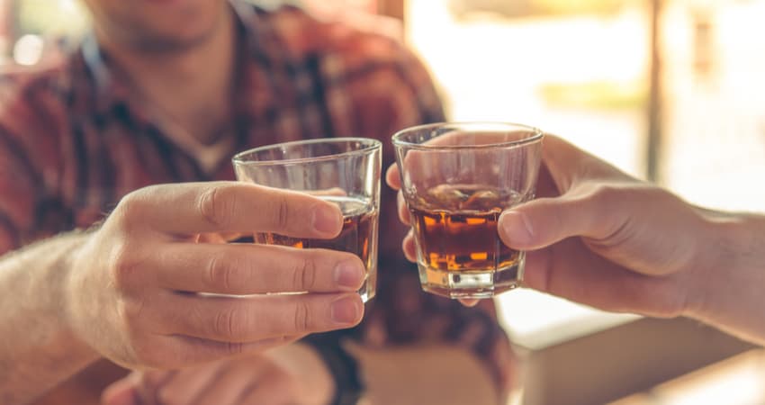 Two friends toasting whiskey samples