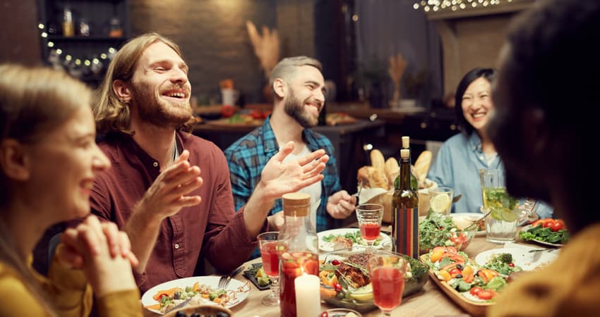 A group of friends smiling and laughing at a restaurant