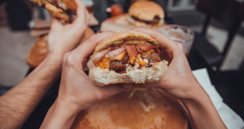 Close up of person'a hand holding a burger