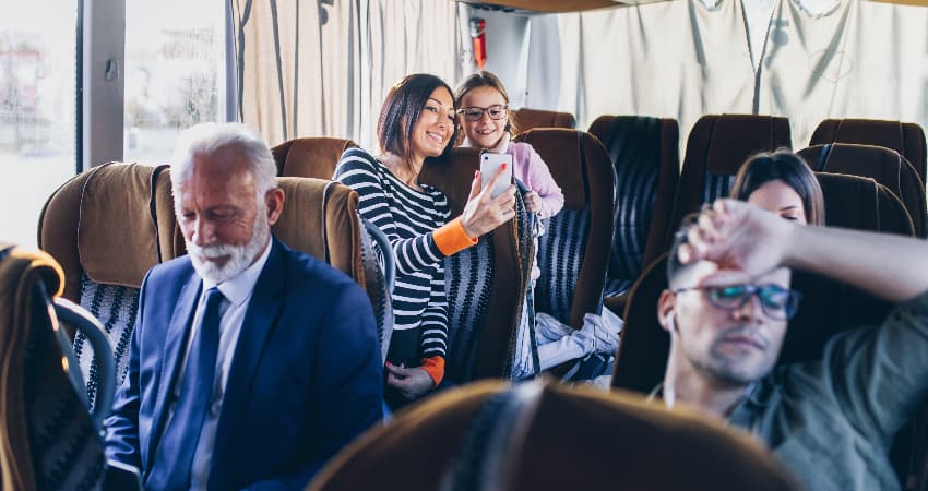 A group of people relax on a charter bus rental during a road trip