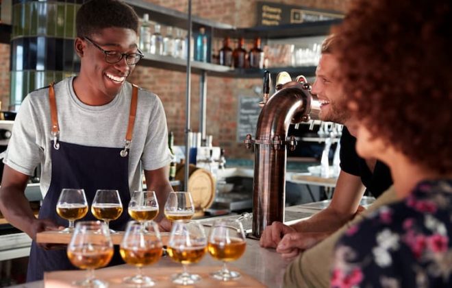 Man serving flight of beers