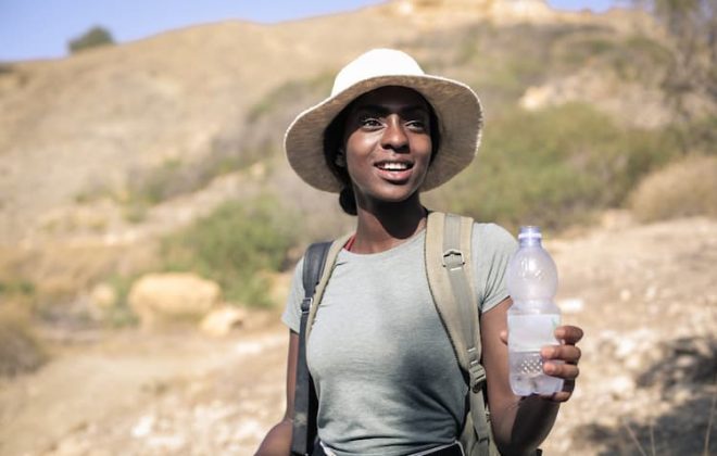 Woman in desert with water bottle